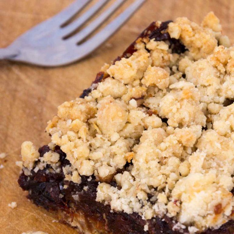 Oatmeal date bars on a cutting board with a fork.