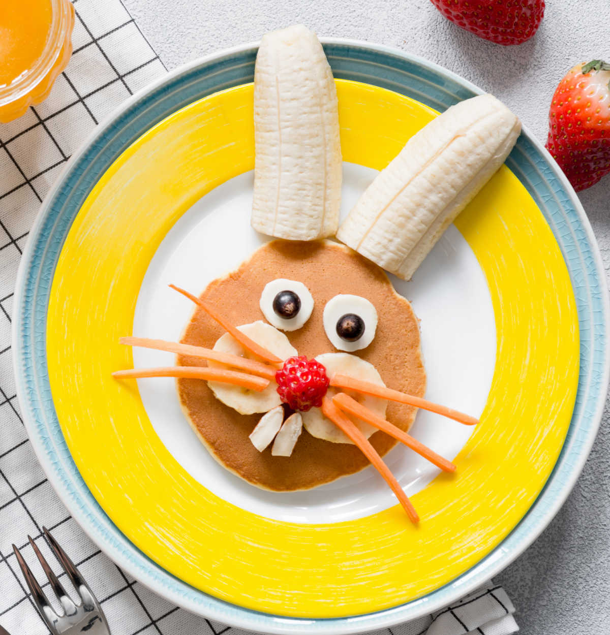 A bunny rabbit made from pancakes, carrots, bananas, and strawberries.