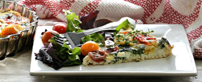 Egg white quiche and salad on a white plate with a fork.