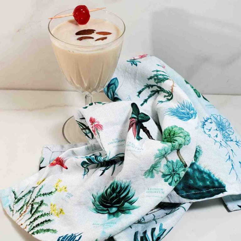 Toasted almond cocktail in a glass with a colorful tea towel.