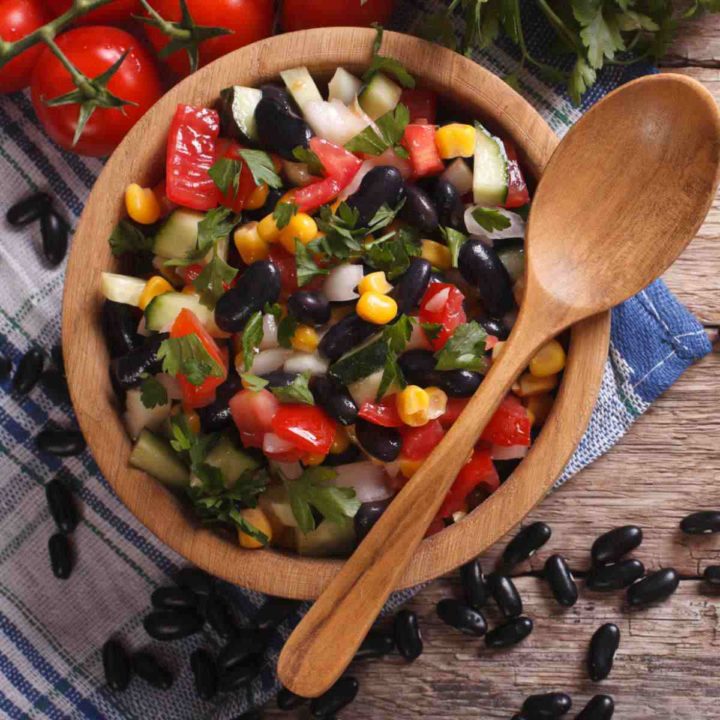 Black bean salsa in a wooden bowl with spoon.