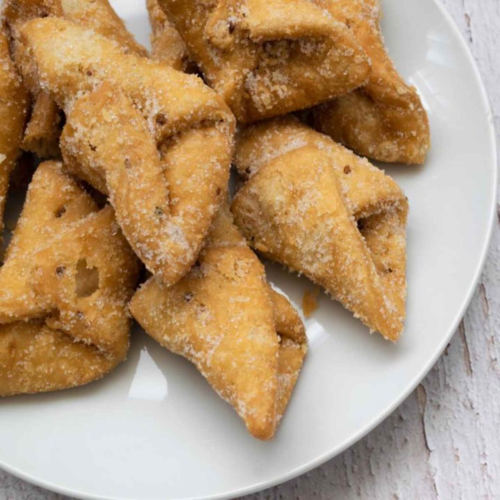 Folded pestinos pastry on a white plate.