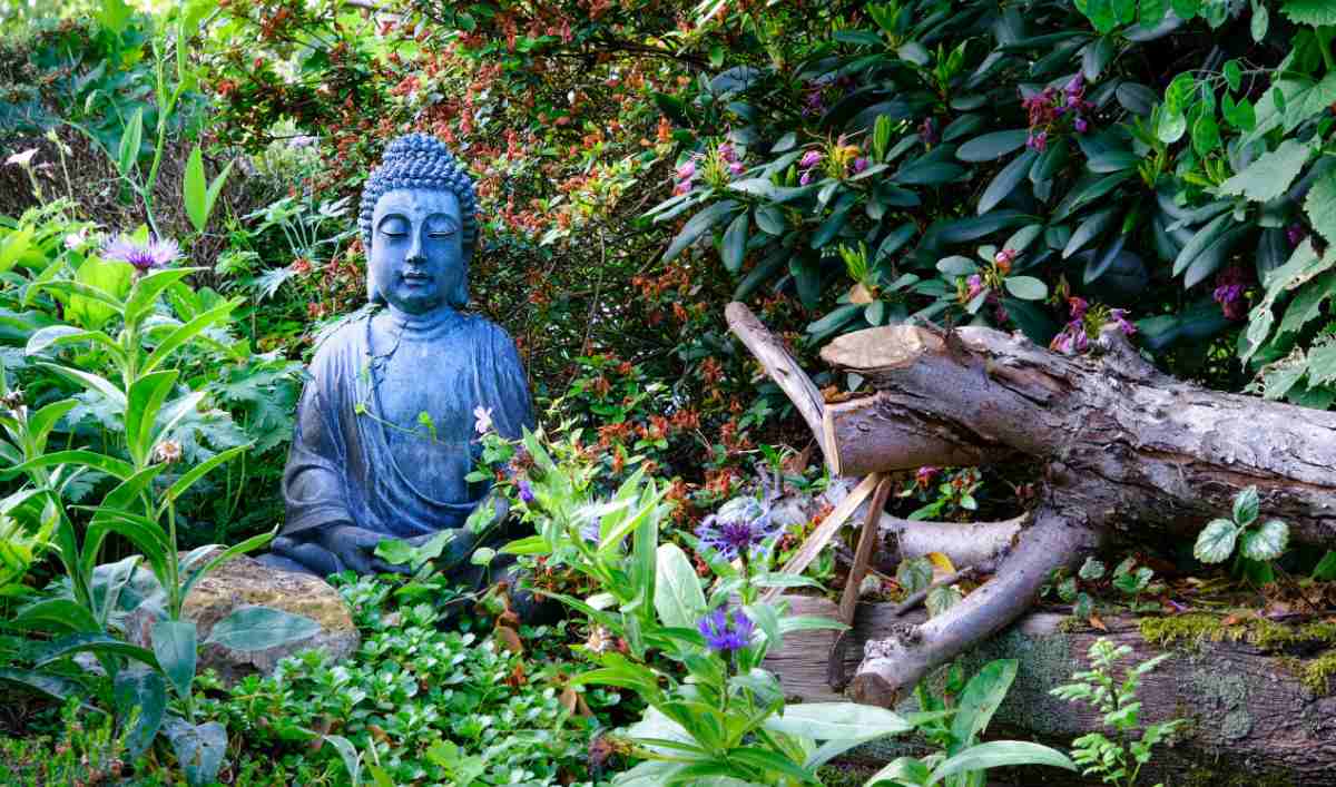 Blue Buddha statue in a meditation garden setting.