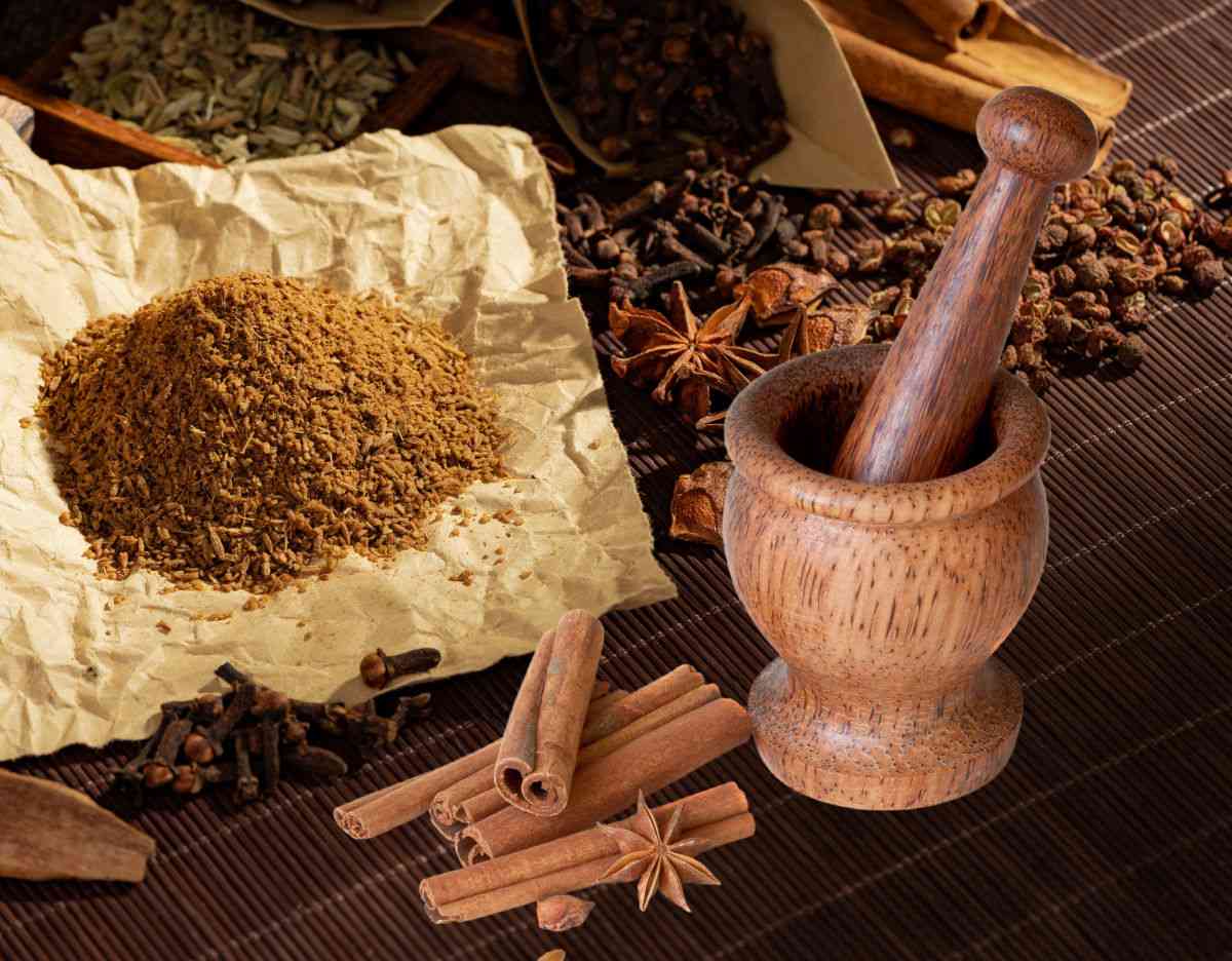 Ingredients for Five Spice Powder near a mortar and pestle.