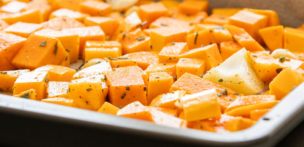 Butternut squash in a baking dish with salt, pepper, oil and a spice mix.