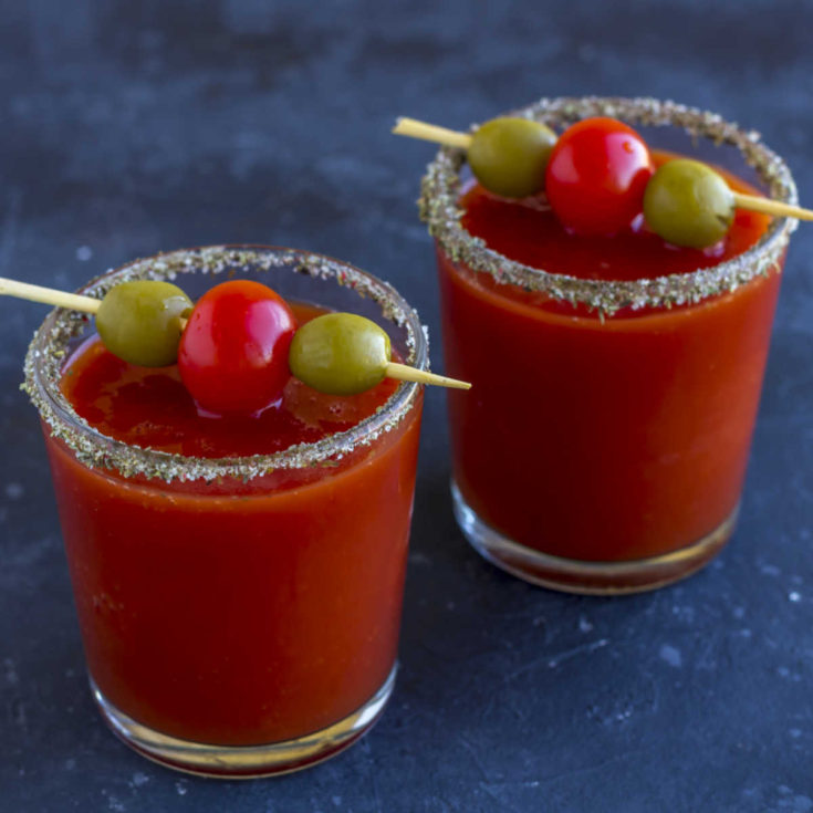 Bloody Mary drinks with olives and salt on rims.