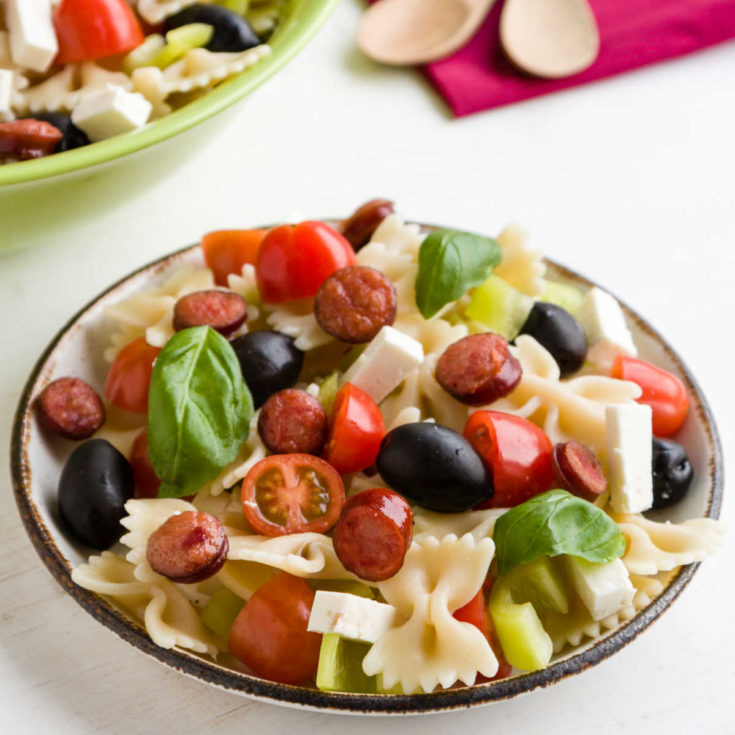Salad with farfelle pasta, olives, basil, mozzarella and tomatoes.