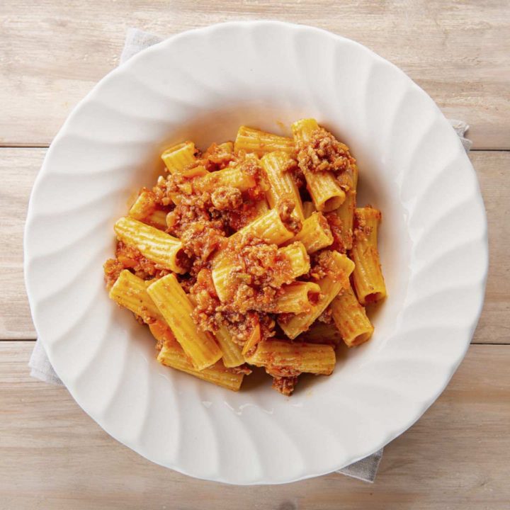 Cheesy pasta in a white bowl.