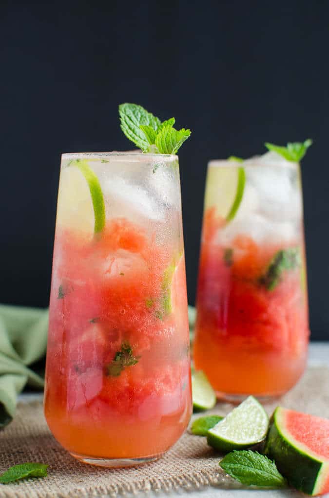 Refreshing watermelon mojitos with mint in two glasses on a black background.