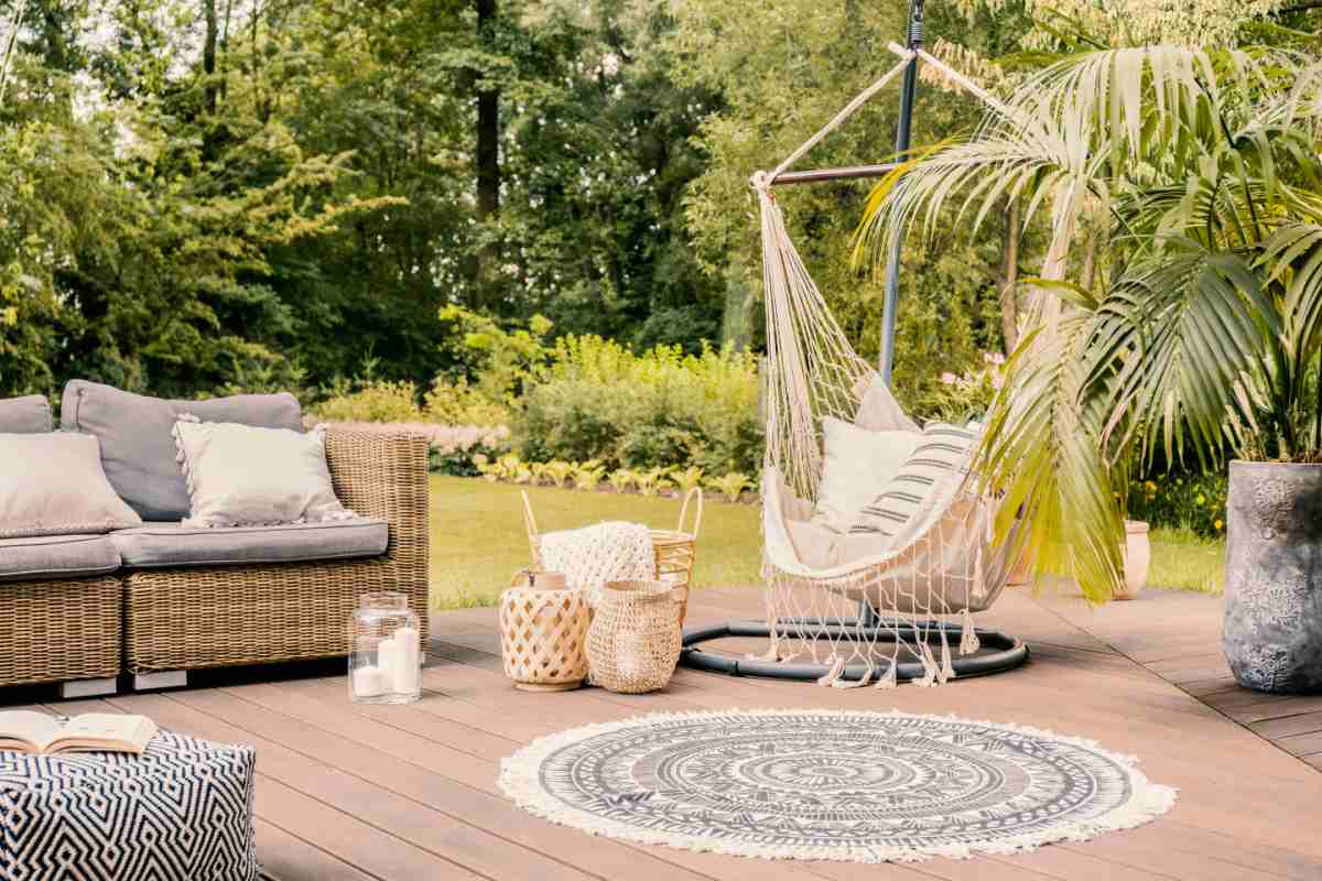 Back yard with seating area and a hammock.
