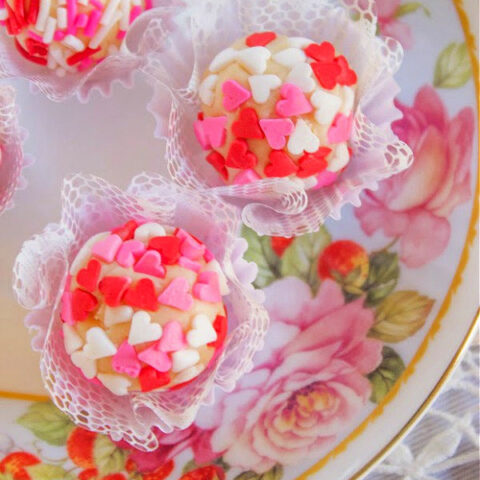 Brigadeiro white chocolate truffles on a flowered plate in mini cupcake liners.
