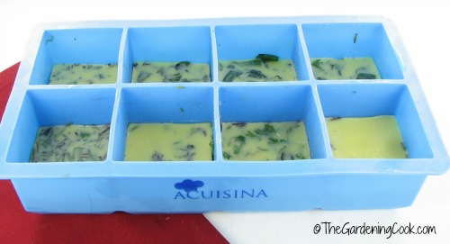 Frozen fresh herbs in butter in silicone ice trays.