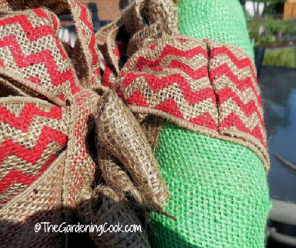 A chevron bow fastened to a green burlap wreath.