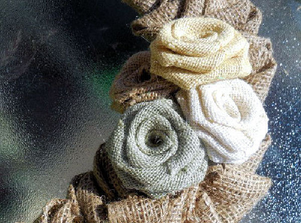 A closeup photo of burlap roses on a burlap flower wreath.