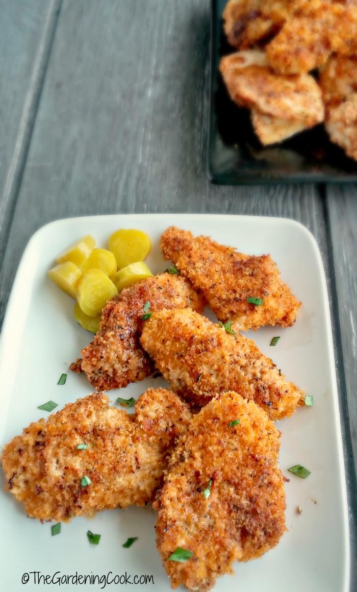 Copycat KFCD oven fried chicken pieces on a white plate with potatoes.