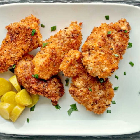 Crispy oven baked chicken on a white plate.