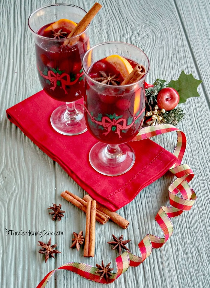 Mulled wine in goblets with red napkins and Christmas decorations.
