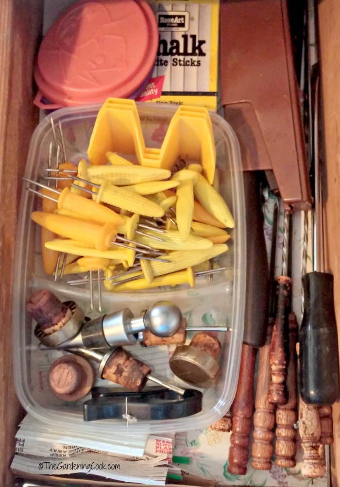 This drawer holds small items not often used and wine stoppers and is kept near the fridge.