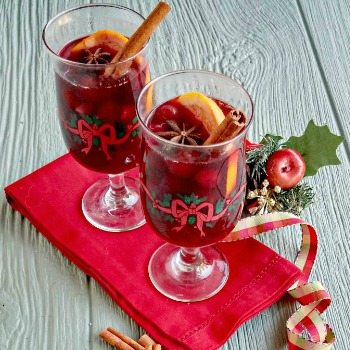 Two mugs of spiced wine with Christmas decoration and a red napkin.