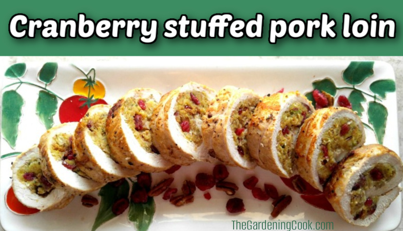 Pork loin with stuffing center on a white plate cut into pieces. Green text box reads cranberry stuffed pork loin.