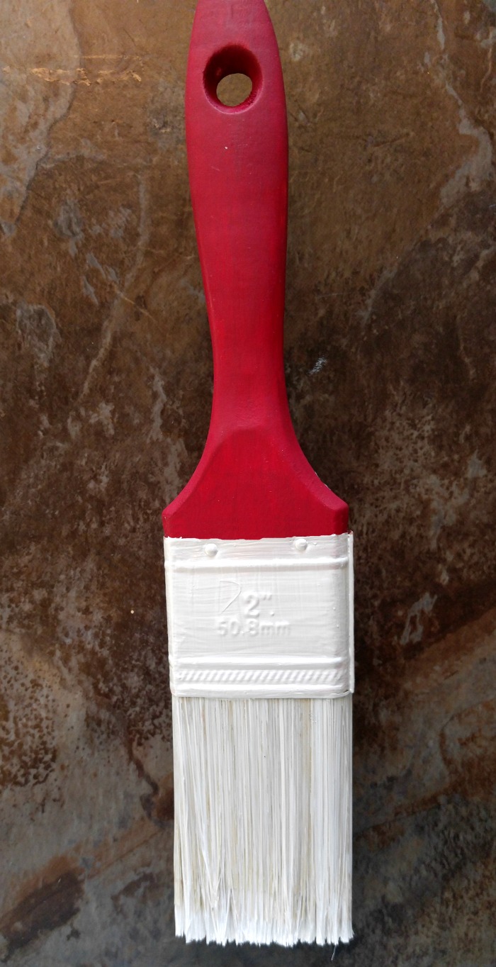 Paint the shank of the paintbrush red and the metal part and bristles white.