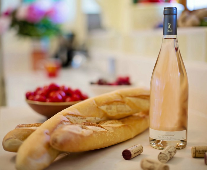 Thinly sliced baguette, tomatoes and bottle of wine.