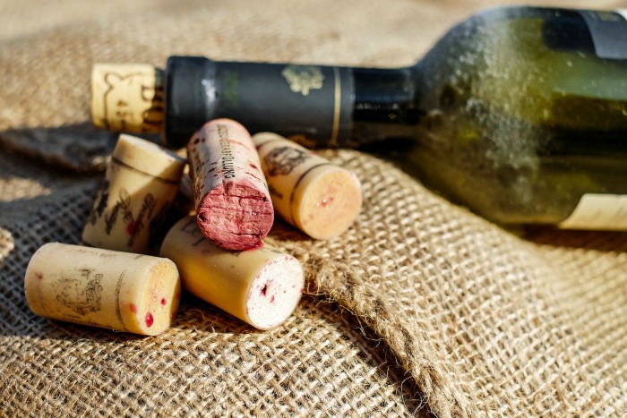 Bottle of wine and wine corks on burlap.