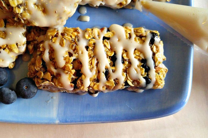 Drizzled blueberry granola bar on a blue plate.