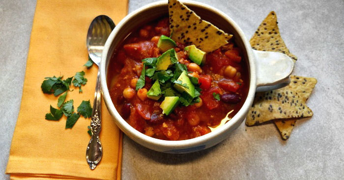 Pumpkin chili for fall Bowl of crockpot turkey chili with tortilla chips, a yellow napkin and a spoon.