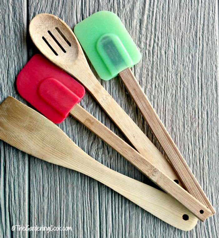 Silicone spatulas and wooden spoons on a wooden counter.