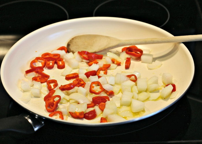 Cooking onions and red peppers in hot oil