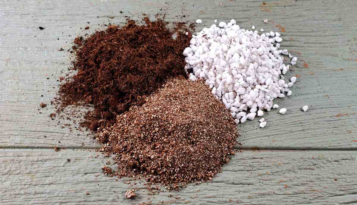 Vermiculite, peat moss and perlite in piles on a wooden board to mix for seed starting.