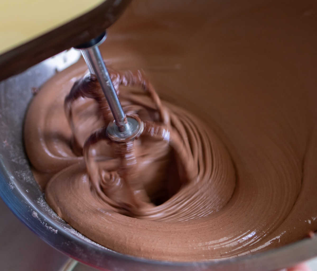 Making chocolate frosting with a mixer.
