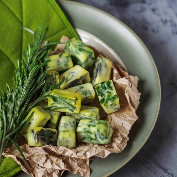 Herbs frozen in olive oil on a gray plate.