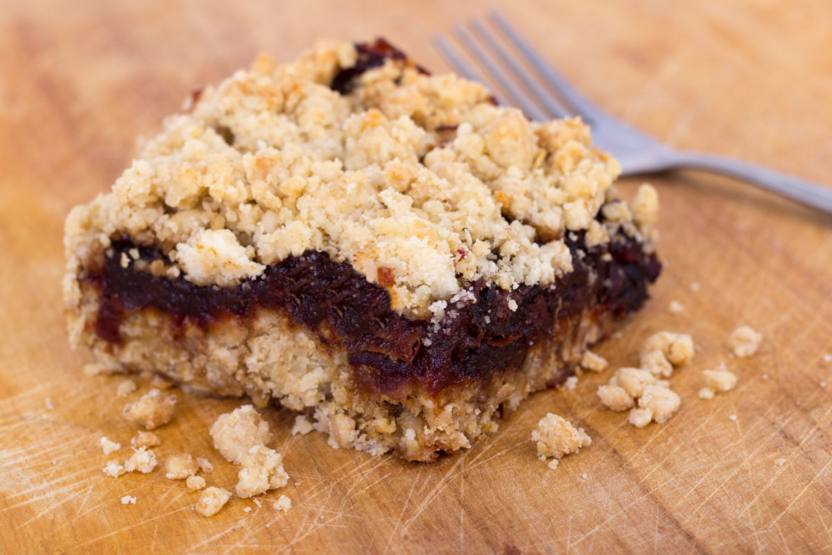 Healthy date oat bar that has a bite out of it, and a fork nearby.