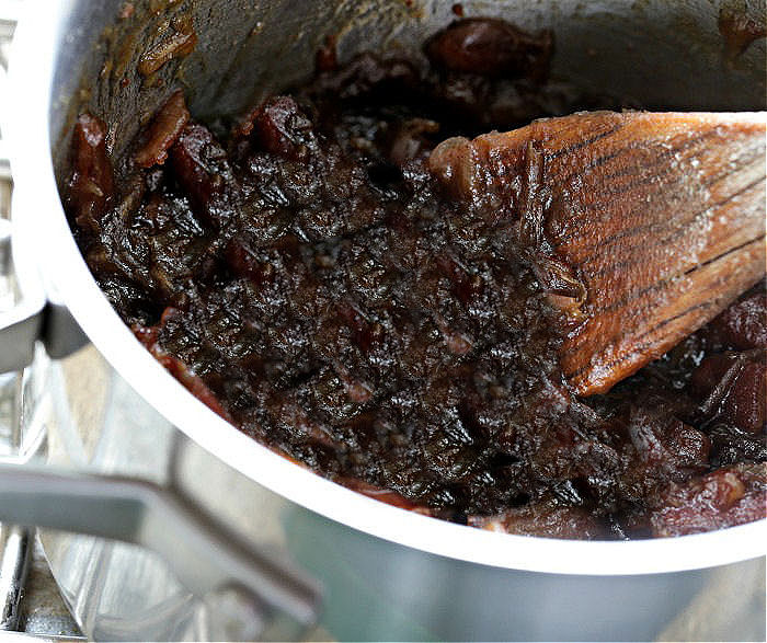 Dates, maple sugar and brown sugar in a saucepan with a wooden spoon.
