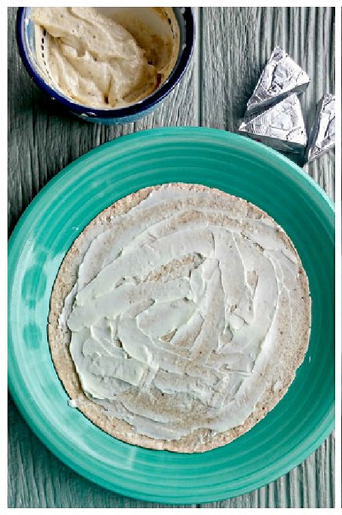 Low-carb tortilla wrap with mozzarella cheese spread to 1 inch from the edges.
