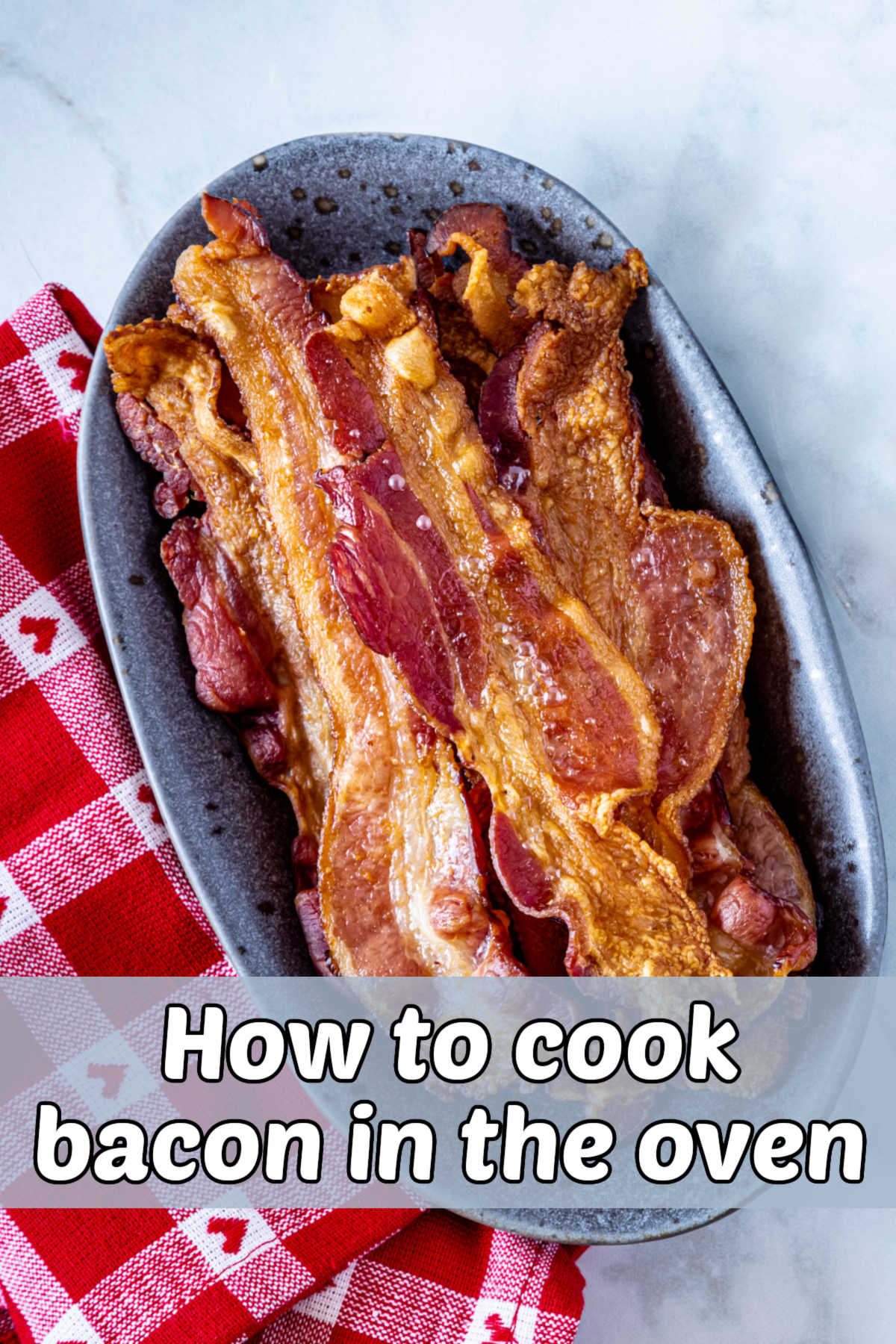 A blue bowl next to a red checked towel with oven cooked bacon in it. Grey text readds How to cook bacon in the oven.