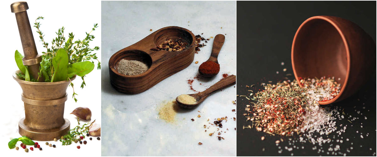 A mortar and pestel with fresh herbs, dried herbs with spoons and a seasoning mix to make honey herb chicken.