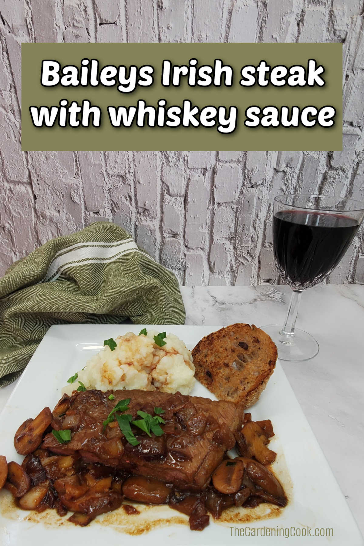Baileys Irish steak with whiskey sauce on a white plate with mashed potatoes and a glass of red wine.