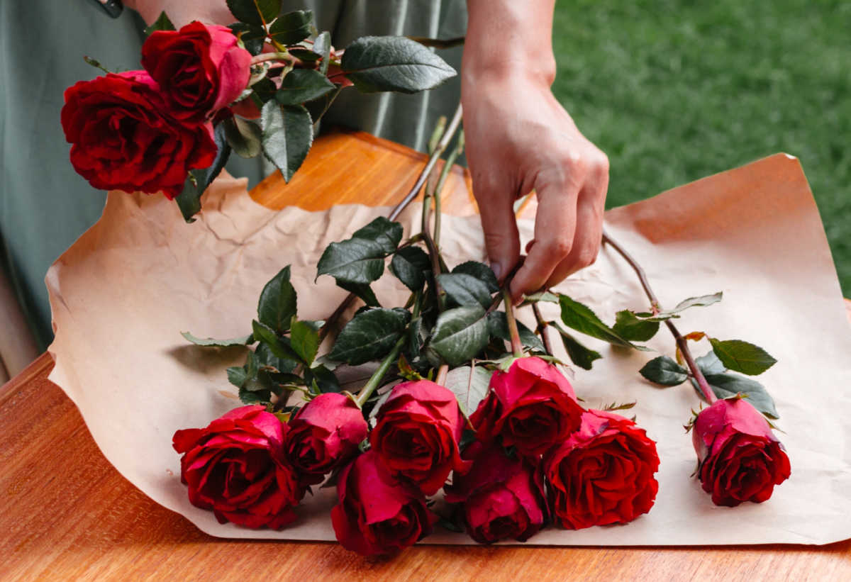 Hands making a bouquet of ten red roses to say that you are perfect.