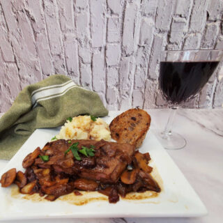 Irish steak with Baileys cream sauce served with mashed potatoes and a glass of red wine.