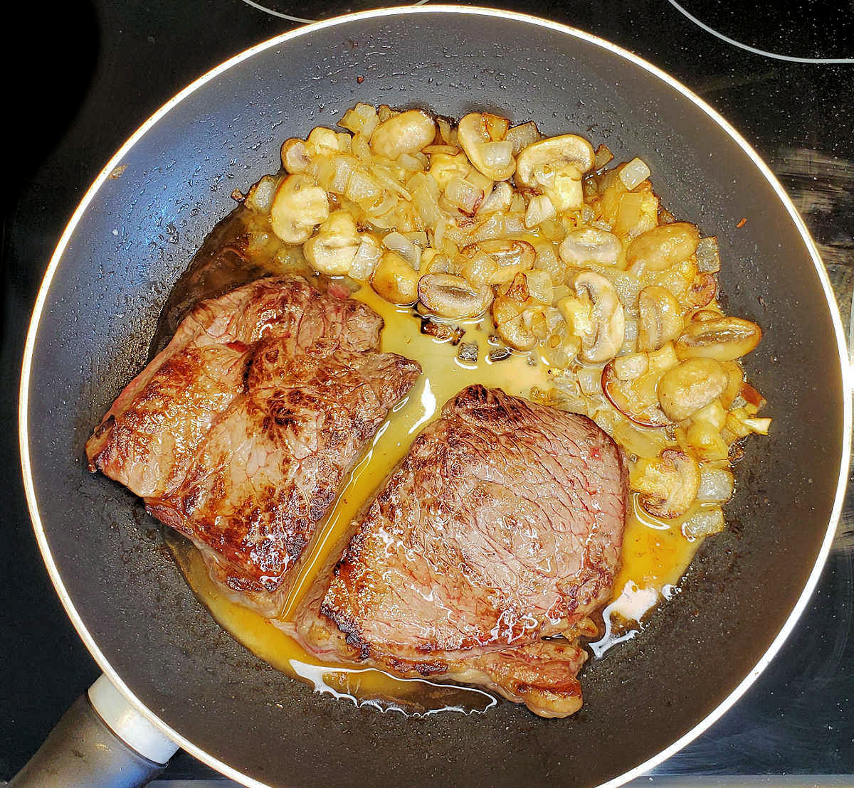 A sirloin steak sauce recipe in a heavy skillet with mushrooms and onions.