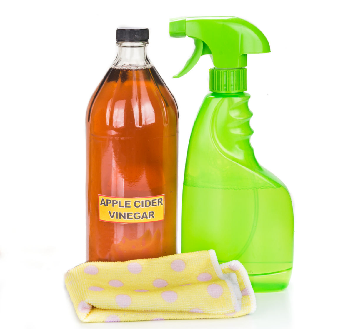 Apple cider vinegar in a bottle next to a cleaning cloth and green spray bottle.
