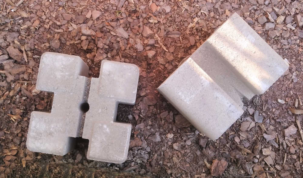 Concrete planter wall blocks in the dirt, ready to make the supports for a DIY raised garden bed.