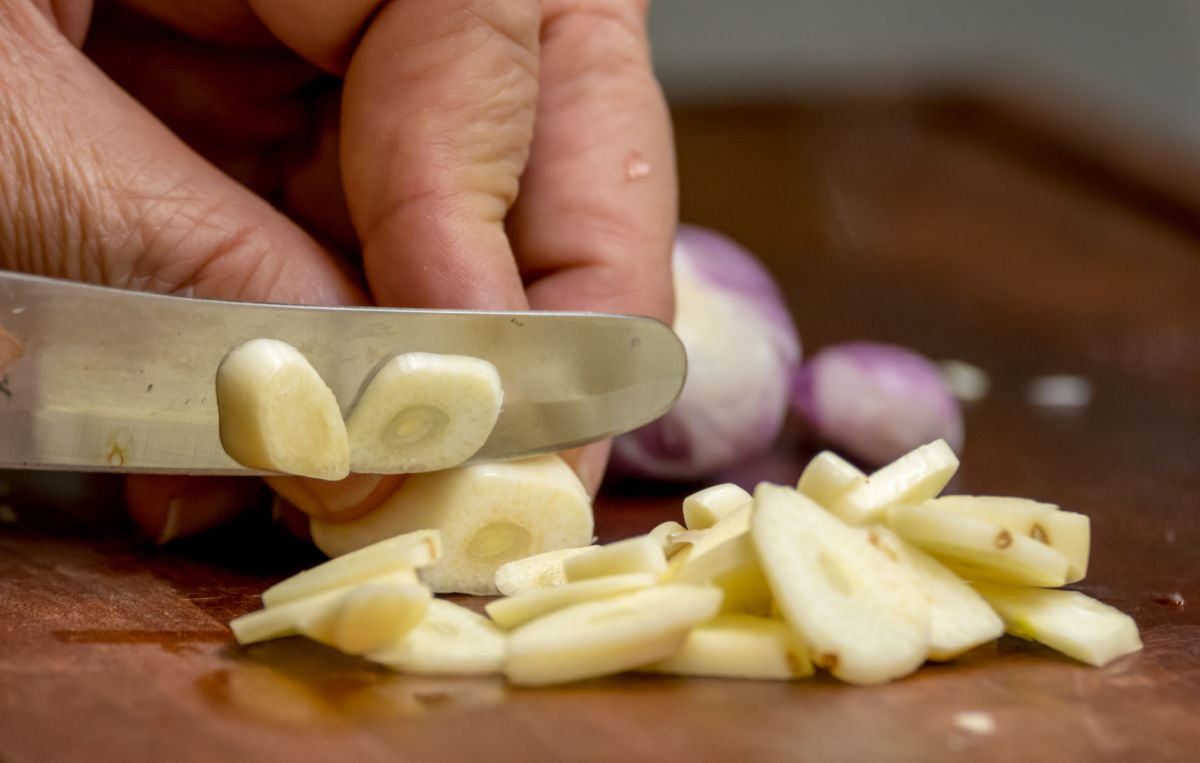 Cutting garlic cloves to repel ants.