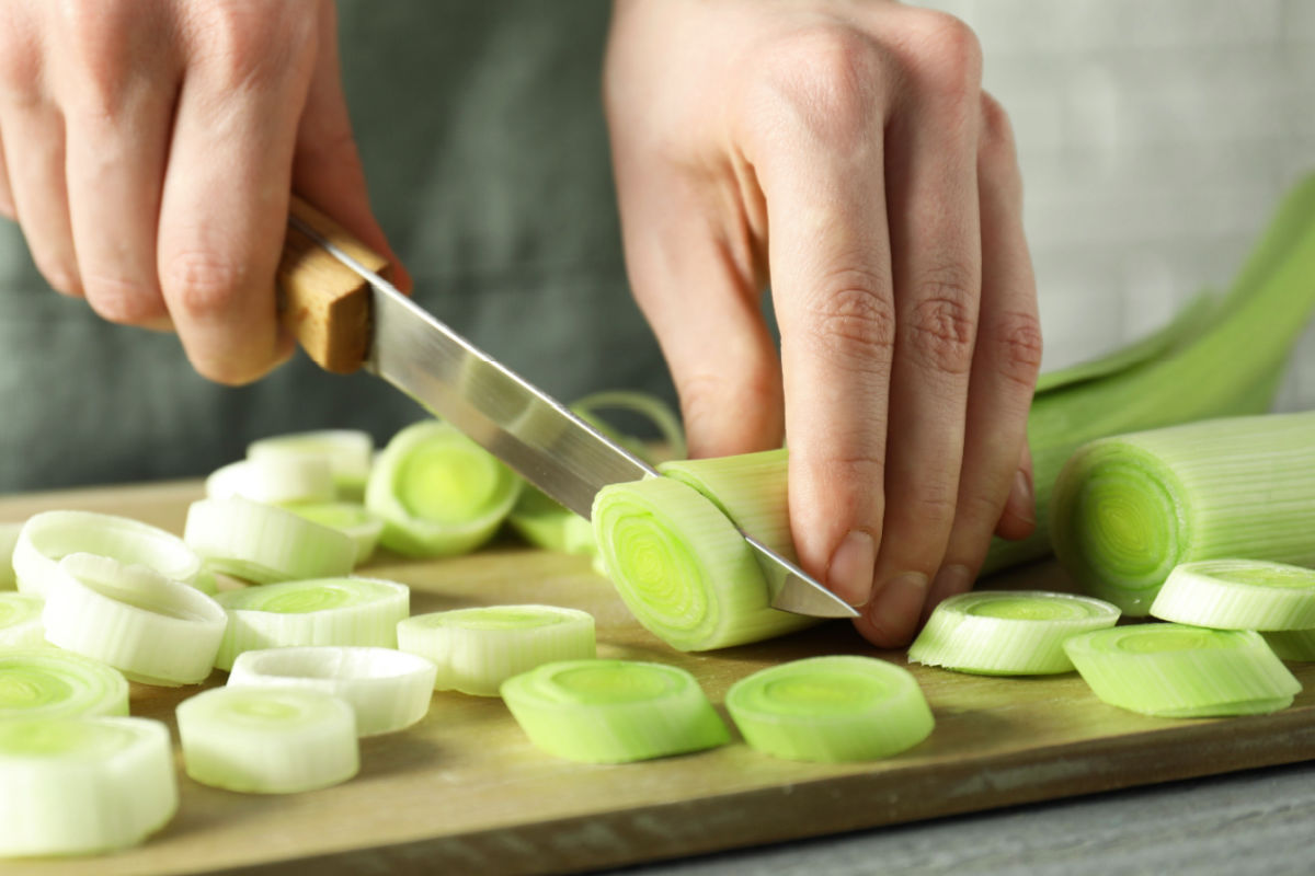 Sliced white and green part of leeks on a cutting board.