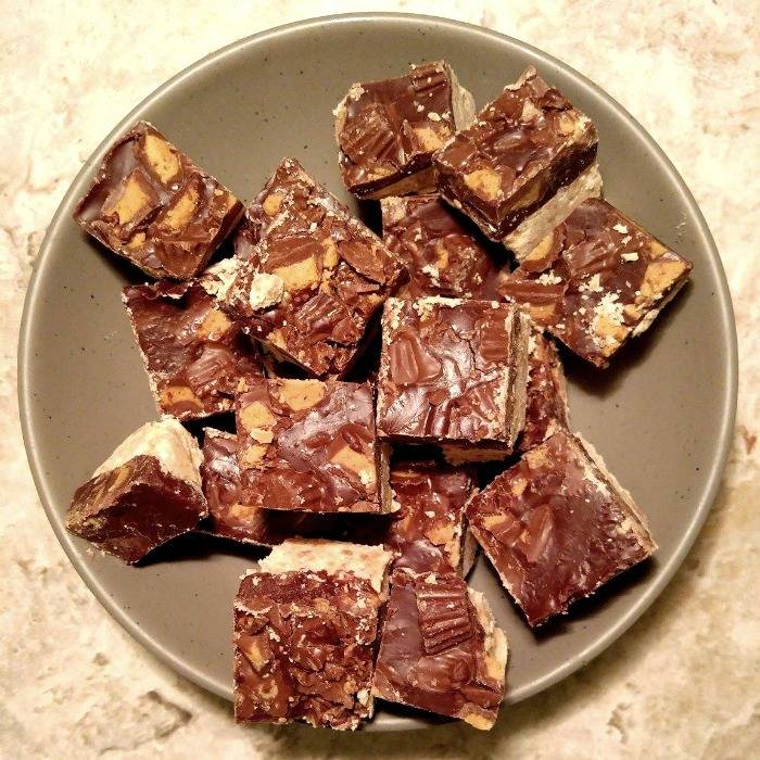 A plate of squares of one of the tastiest Xmas fudge recipes, which is a chunky Reese's peanut butter fudge.