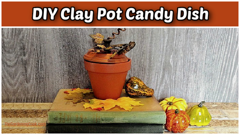 A stack of old books with a DIY clay pot candy dish sitting on top of them.